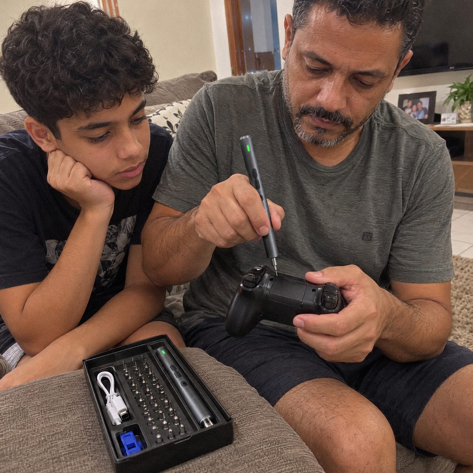 Pai abrindo o controle de videogame com a Chave de Fenda Elétrica Carbon